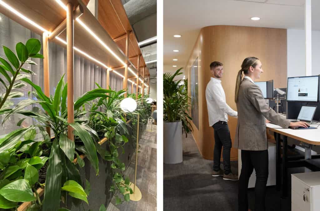 Office plants layered next to two happy employees working a front desk
